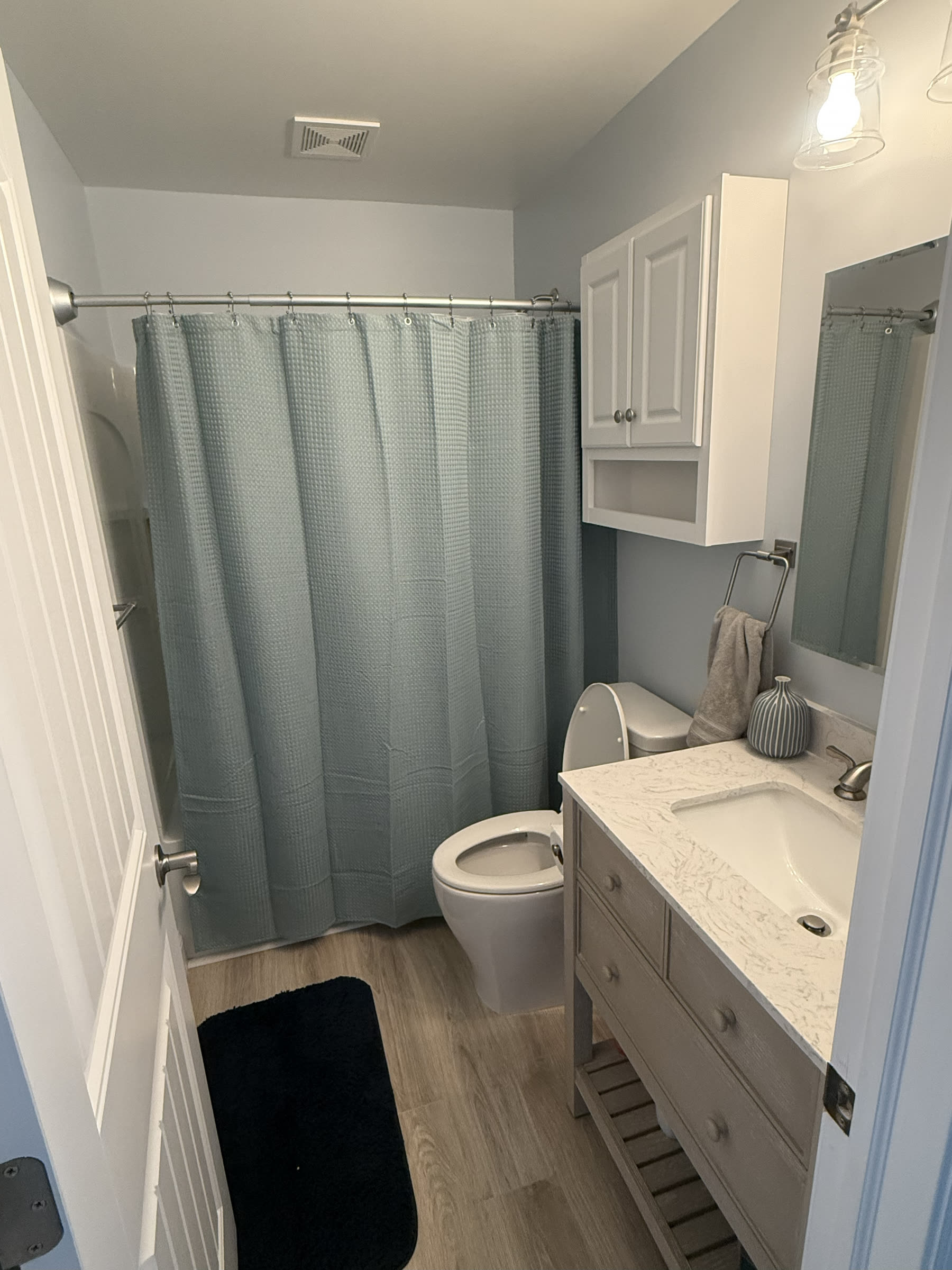 Updated bathroom inside a Yacht Avenue condo with soft blue walls, white vanity, and modern fixtures