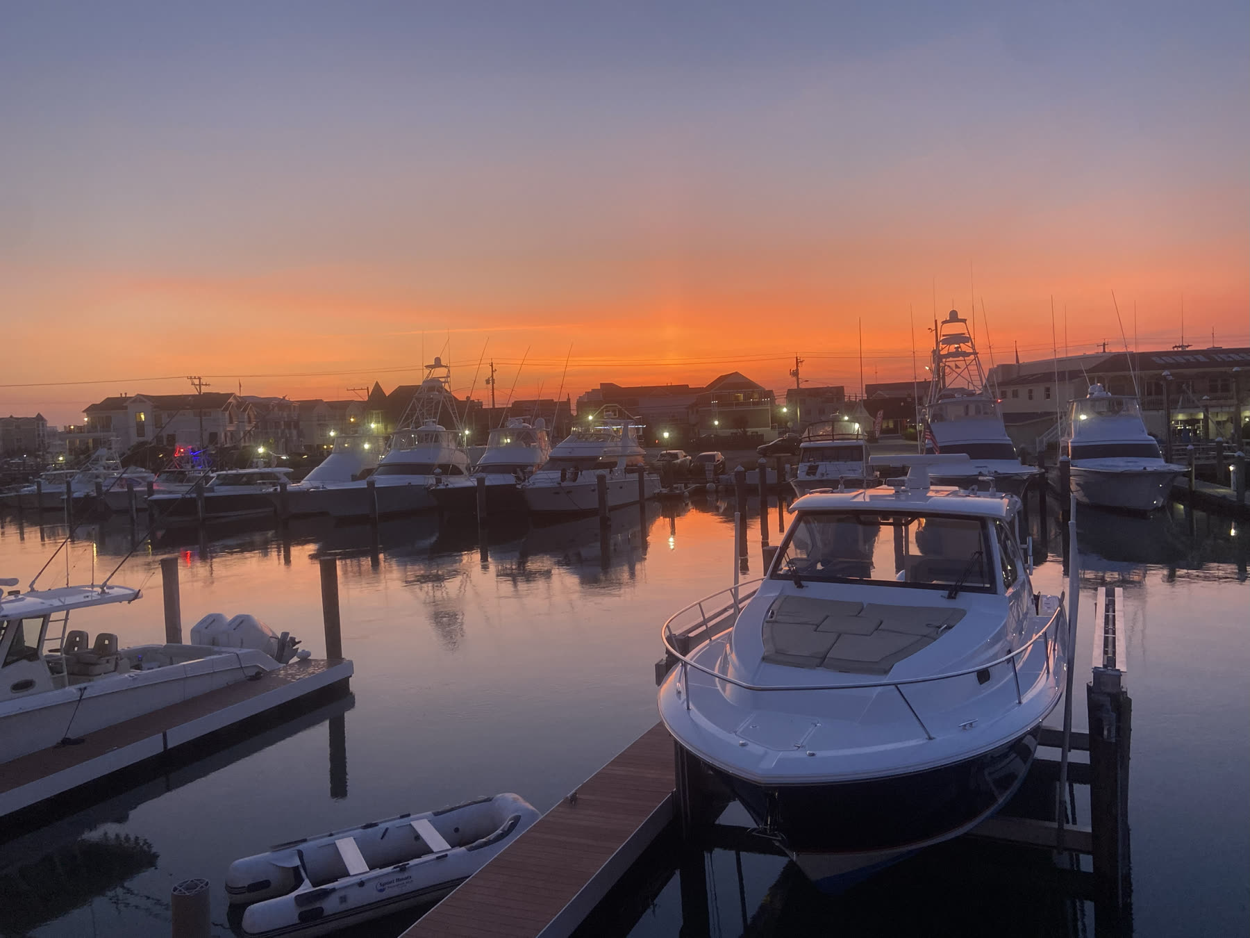 Twilight view of the Cape May yacht marina with boats and a glowing horizon