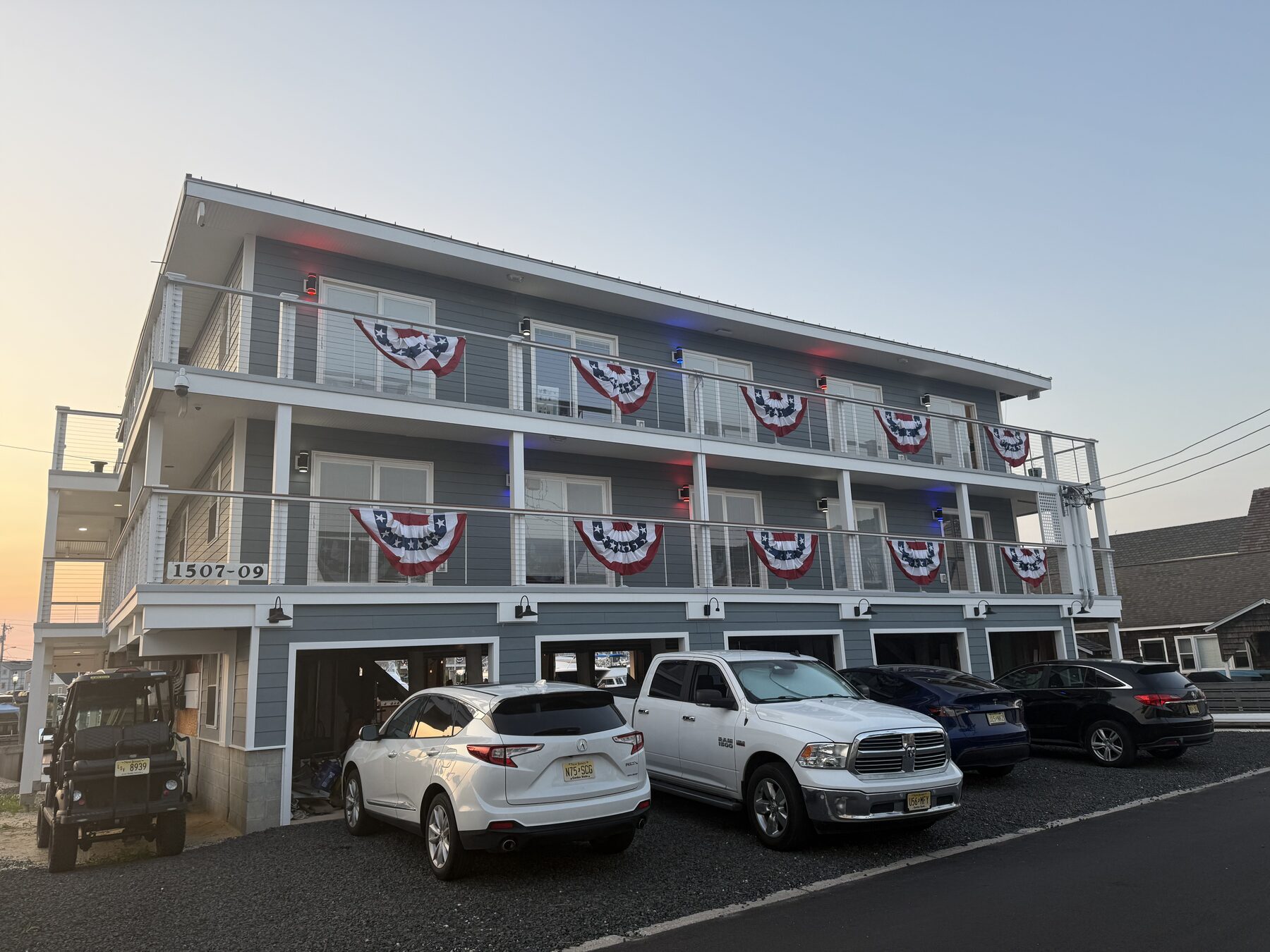 Front of Yacht Avenue Condos at golden hour with red, white, and blue patriotic bunting hanging from every balcony railing